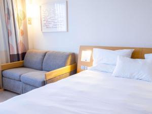 a bedroom with a bed and a couch at Novotel Mulhouse Bâle Fribourg in Sausheim