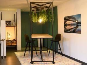 a table and chairs in a room with a green wall at Novotel Antwerpen - Ekeren in Antwerp +121 photos