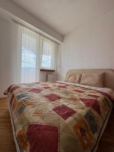 sypialnia z łóżkiem z kolorową kołdrą w obiekcie Alex Apartment w mieście Skopje