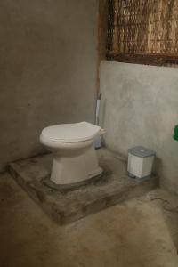 a bathroom with a toilet and a trash can at Bubble Paradise, Koh ta Kiev in Koh Ta kiev Island