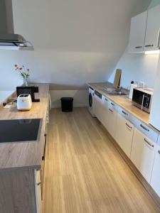 a kitchen with white cabinets and wooden counter tops at promedklinik apartment 2 in Volkach