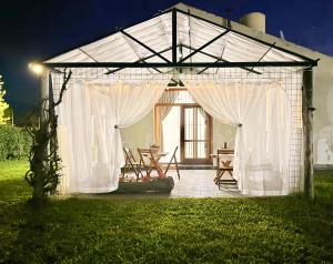 ein Pavillon mit weißen Vorhängen und Stühlen in einem Hof in der Unterkunft Casa Raíz in Villaguay