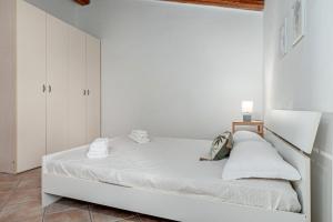 a white bedroom with a large white bed at Residence Orizzonti 33 in Golfo Aranci
