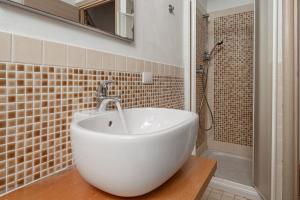 a bathroom with a white sink and a shower at Residence Orizzonti 33 in Golfo Aranci +19 photos