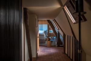 a hallway with a room with a bed and a bathroom at Cour des Vosges - Evok Collection in Paris +18 photos
