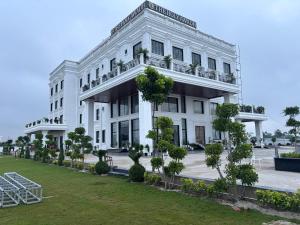 a white building with trees in front of it at The Holy Awadh Hotel in Ayodhya