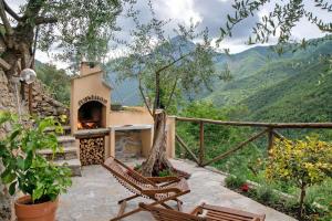 a patio with a pizza oven with mountains in the background at Agriturismo U'Spigu Nonna Annetta in Nasino