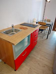 a kitchen with a sink and a red cabinet at B&b La Lucciola in Salsomaggiore Terme