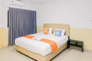 ブンクルにあるSANS Stay Manlie Hotel & Residenceのベッドルーム1室(大型ベッド1台、カラフルな枕付)