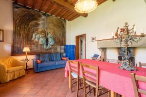 a dining room with a red table and a blue couch at Appartamento Mulino in Laterina