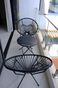 two black chairs sitting on top of a balcony at Maurentvilla in Pointe aux Piments