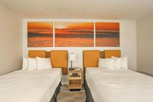 a hotel room with two beds and a painting on the wall at Hotel Carolina - Double Room 2 Full Beds in Hilton Head Island