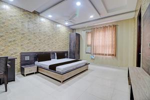 a bedroom with a bed and a brick wall at Grand Townhouse in Palwal +33 photos