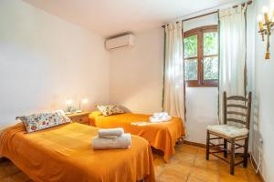 a room with two beds and a chair and a window at Fuente Del Baden in Nerja