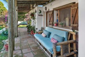 a porch with a blue couch on a patio at Casa Inma in Vejer de la Frontera