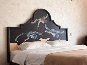a bed with a large headboard with birds painted on it at Kyiv Panna Apartment in Kyiv