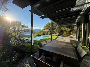 an outdoor patio with a table and a pool at Villa Teixugueiras 2 - Gerês in Vieira do Minho