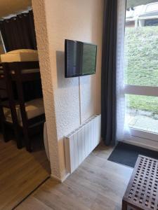 ein Wohnzimmer mit einem Flachbildfernseher an der Wand in der Unterkunft Les marmottes in Aragnouet