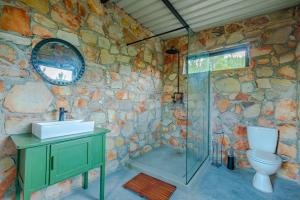 HouhoekにあるBumbrah Camp and Glampの石壁のバスルーム(洗面台、トイレ付)