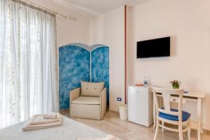 a bedroom with a chair and a desk and a television at bed and breakfast Tallyho in Salve