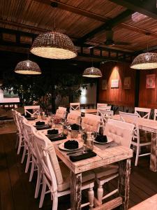 a long wooden table with white chairs and lights at 1-Bedroom Apt 3mins to Beach & Private Restaurant - TRR3 in Pointe aux Cannoniers