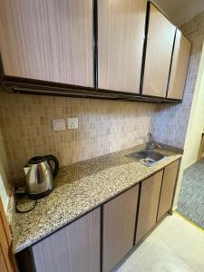 a kitchen with a sink and a counter top at فندق نزلي المعابدة in Miná