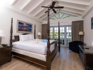 a bedroom with a large bed with a ceiling fan at Savannah Beach Club Hotel in Bridgetown