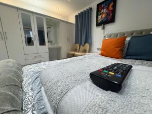 un mando a distancia sentado sobre una cama en WBC R1 - Modern Large Ensuite Room - Wednesbury, en Bilston