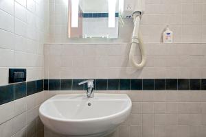 La salle de bains est pourvue d'un lavabo et d'un téléphone mural. dans l'établissement Appartamento Boboba, à Marina di Pisa