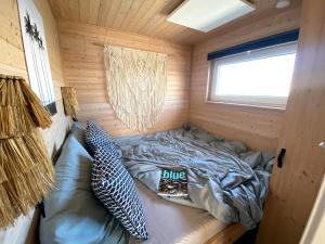a bed in a wooden cabin with a window at Hausboot Koje Kaete mit großem Sonnendeck in Schleswig in Schleswig