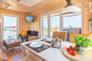 a kitchen and living room with a view of a boat at Hausboot Smaragd Heiligenhafen in Heiligenhafen