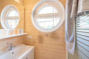 a bathroom with two windows and a sink at Hausboot Smaragd Heiligenhafen in Heiligenhafen