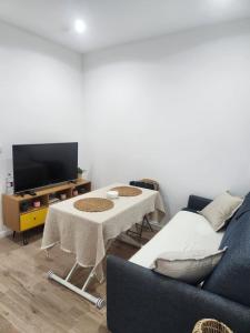 uma sala de estar com um sofá, uma mesa e uma TV em apartamento en el 10 em Paris
