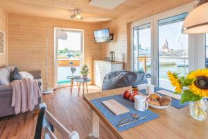 a kitchen and living room with a table with food on it at Hausboot Smaragd Heiligenhafen in Heiligenhafen +7 photos