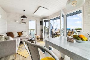 a kitchen and living room with a table and chairs at Nessie in Kragenæs