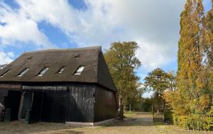 a black barn with a gambrel roof at Schaapskooi 20 in Dwingeloo