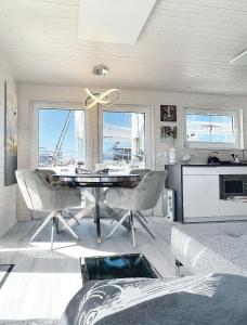 a dining room with a table and chairs and a kitchen at STERN V Hausboot Heiligenhafen in Heiligenhafen