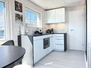 a small kitchen with white cabinets and a table at STERN V Hausboot Heiligenhafen in Heiligenhafen