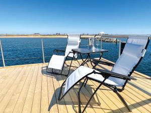 a deck with a table and chairs on a boat at STERN V Hausboot Heiligenhafen in Heiligenhafen