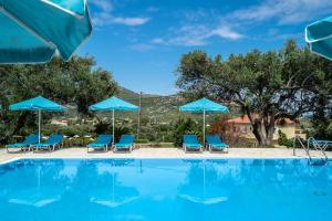 a swimming pool with blue chairs and umbrellas at Anemona studio D in Katelios +12 photos