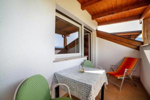 une petite table et des chaises sur un balcon avec une fenêtre dans l'établissement Gasserhof Ferienwohnung Jonagold, à Caines