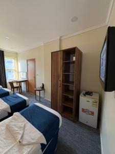 a hotel room with two beds and a tv at فندق نزلي المعابدة in Miná