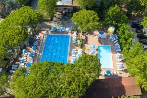 an overhead view of a swimming pool with blue umbrellas at Camping Village Punta Navaccia in Tuoro sul Trasimeno