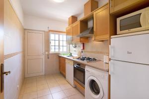 eine Küche mit einem weißen Kühlschrank und einem Geschirrspüler in der Unterkunft Algarve apartments J in Olhos de Água