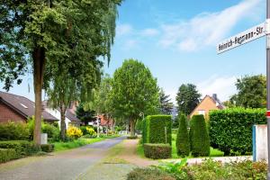 a street sign in front of a house with hedges at Tiny Appartment Xanten am See in Xanten