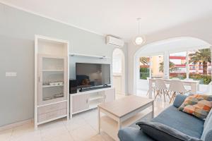 een woonkamer met een bank en een tv bij Apartamento Sol Playa Torrox A55 in Torrox Costa