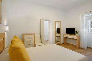 a bedroom with a bed and a desk with a television at Finca Rural Mar de Nubes in Vega de San Mateo