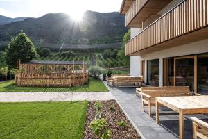a patio with benches and a view of the mountains at Oberfallerhof Apartment Aui in Barbiano +14 photos