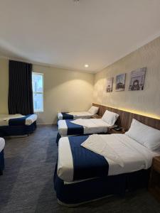 a hotel room with four beds in a row at فندق نزلي المعابدة in Miná