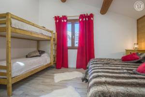 a bedroom with two bunk beds and red curtains at Gîte Les Mélèzes in Termignon